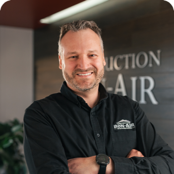 Portrait d’un membre de l’équipe de Construction Bon-Air en chemise noire devant le logo