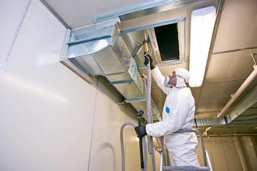 Technicien nettoyant un conduit de ventilation métallique industriel